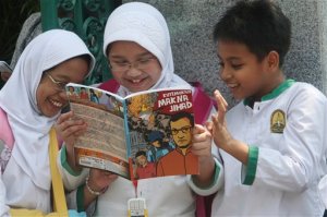 Students read a comic book with an anti-extremist theme at a primary school Friday, Sept. 9, 2011 in Jakarta, Indonesia. The real life adventures of former al-Qaida-linked terrorist Nasir Abas have become a new comic book in Indonesia, chronicling his transformation from militant to invaluable ally in the fight against terrorism. (AP Photo/Tatan Syuflana)